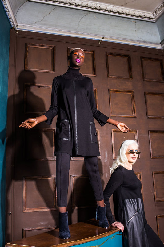 Two women in black outfits standing in a room with wooden paneling. Japanese fabric 