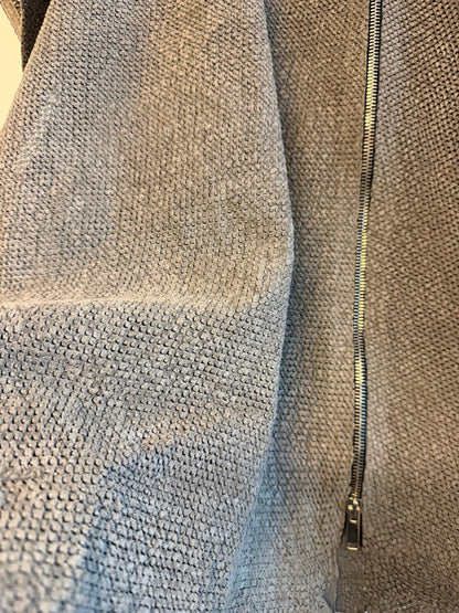 Close-up of a textured real lamb leather with a zipper running along the top edge.